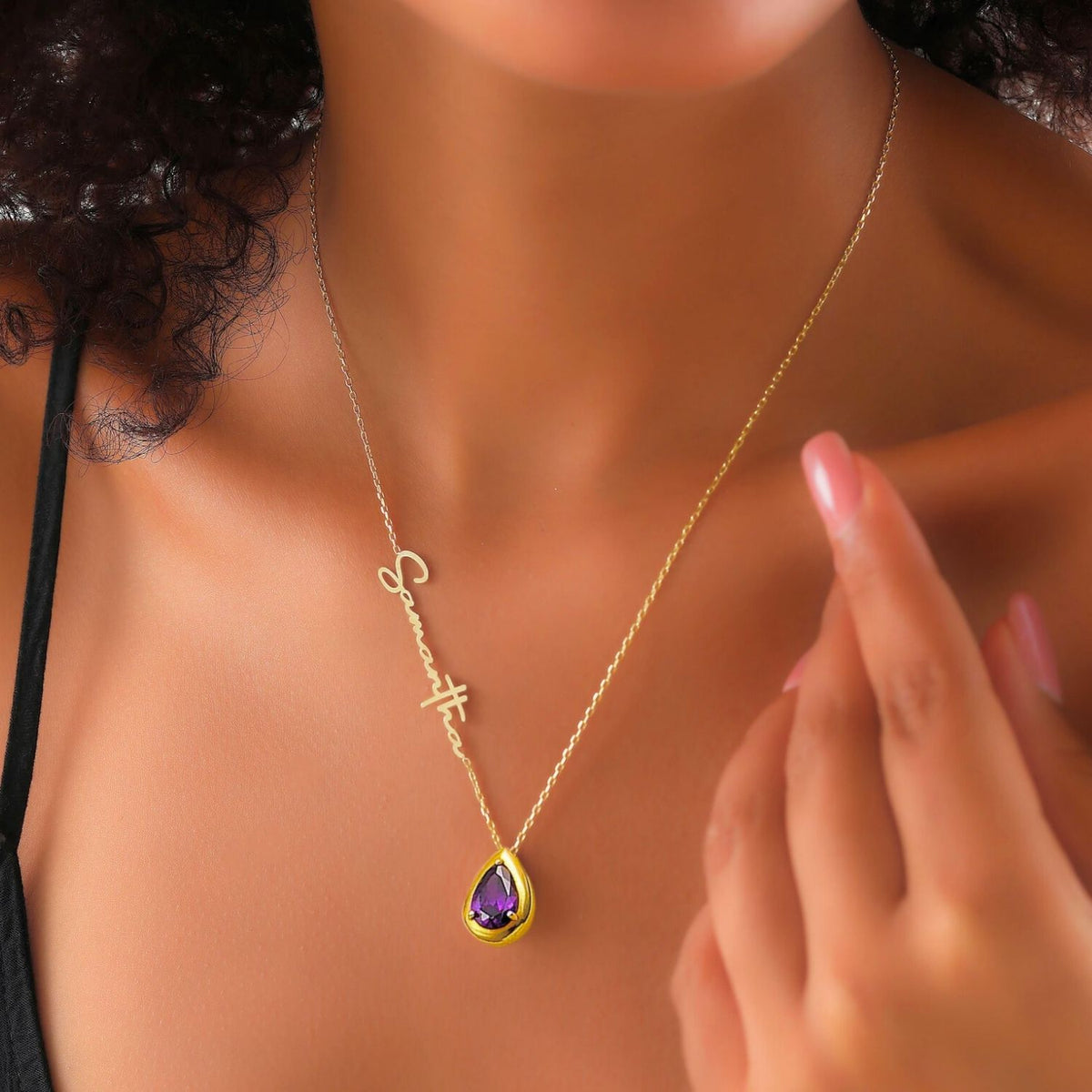 Gold necklace with a purple amethyst pendant on a woman