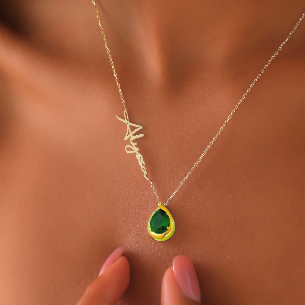 Necklace with an emerald teardrop pendant on a woman's neck