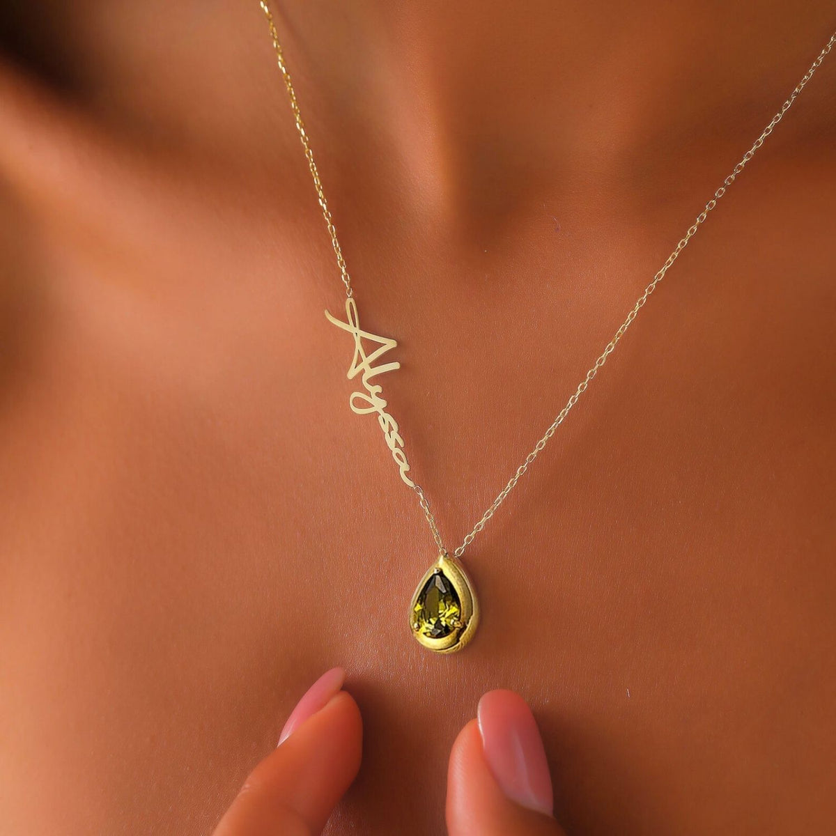 Necklace with a teardrop-shaped peridot gemstone on a woman's neck against a brown background