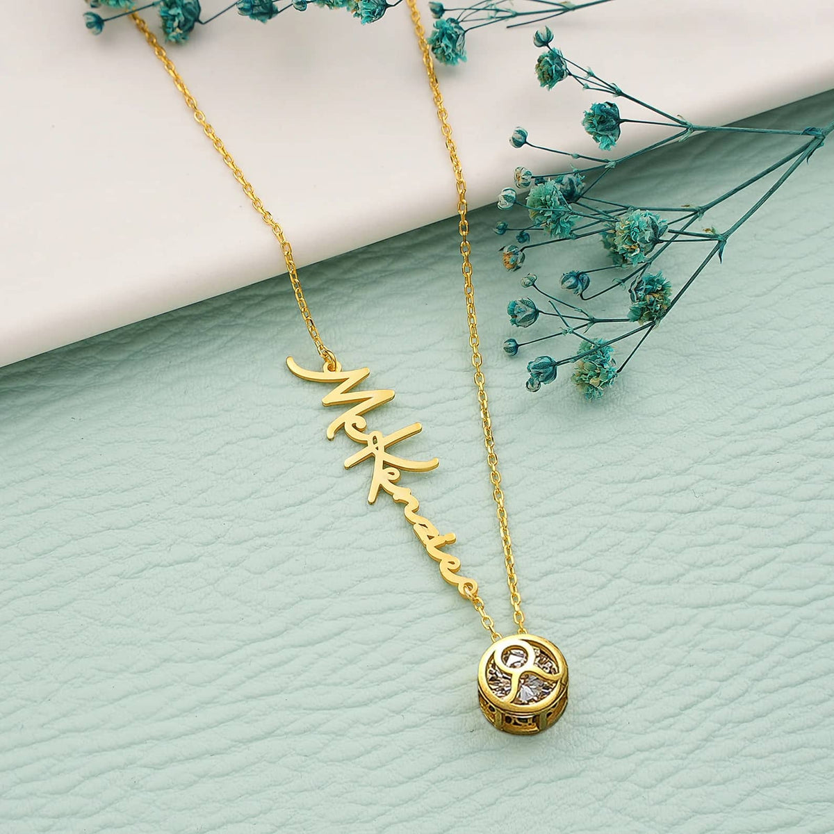 A gold cable chain necklace with a round pendant featuring a diamond embedded in a Taurus zodiac charm