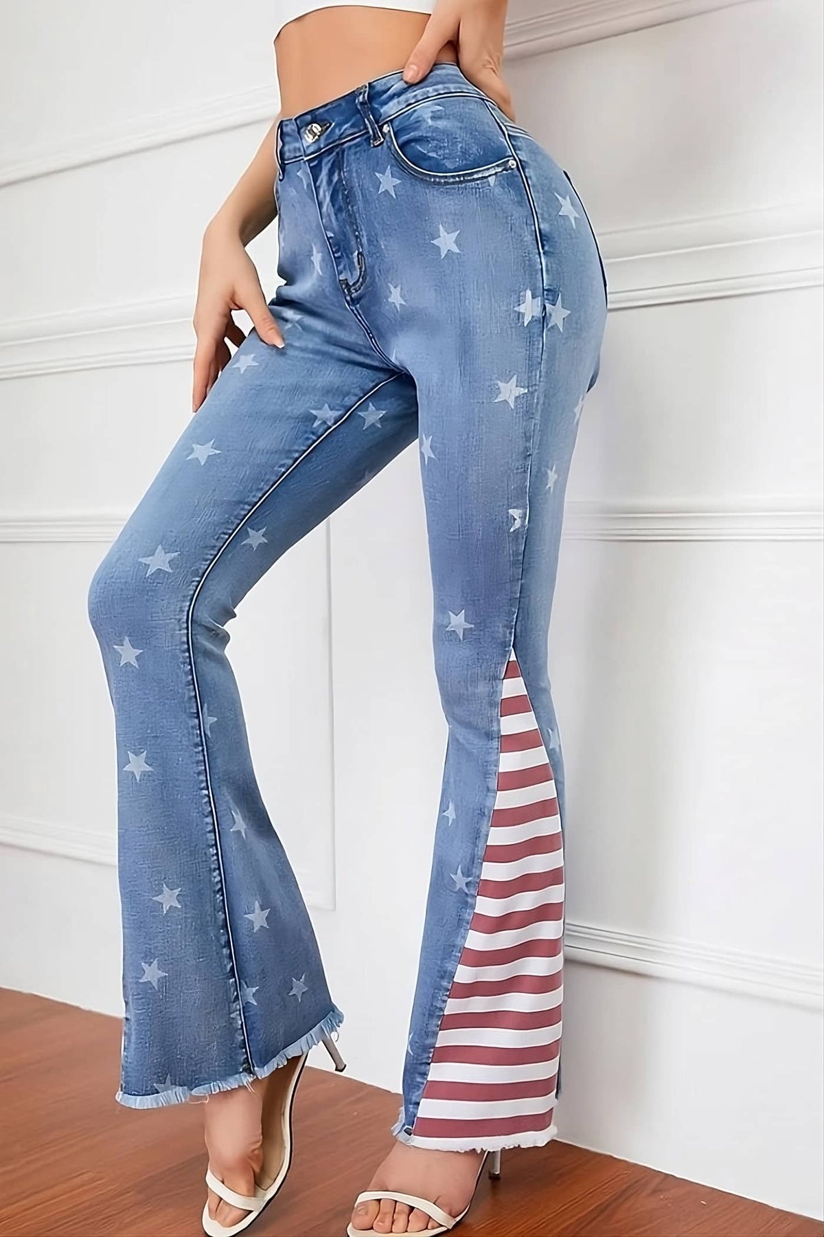 A pair of flare jeans with stars and stripes print, featuring a high-rise waist and raw-edge hem detailing
