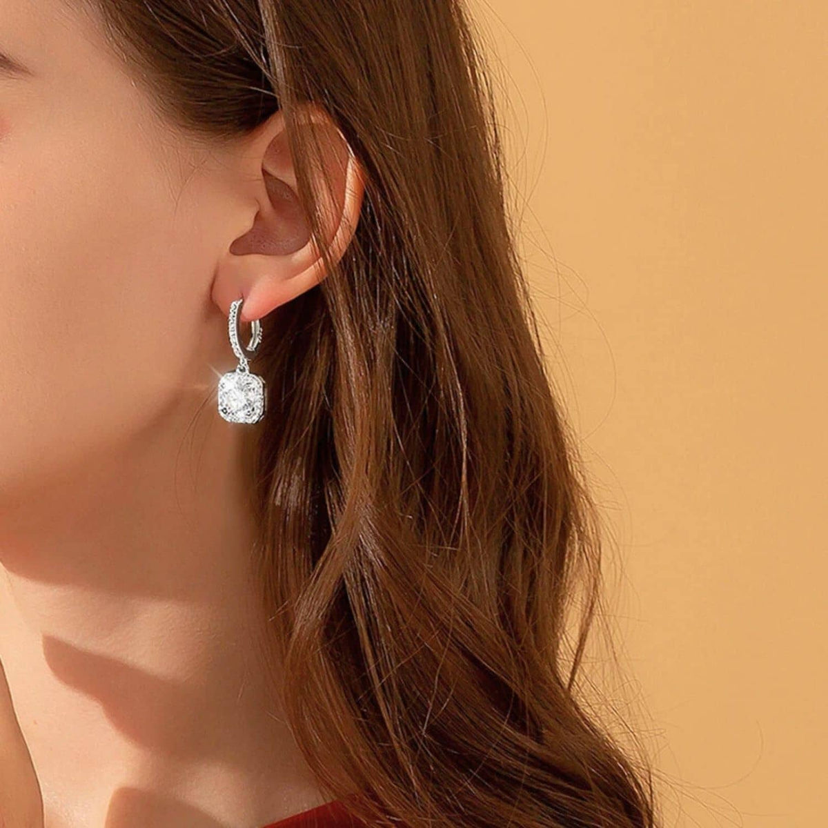 Elegant white gold moissanite diamond dangle earrings displayed on model