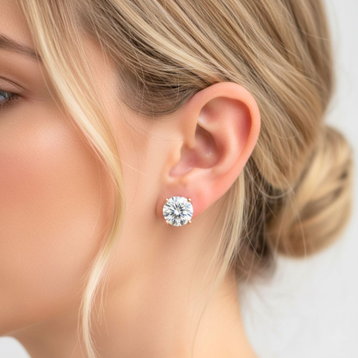 Close-up of a woman wearing a diamond stud earring with a blurred background