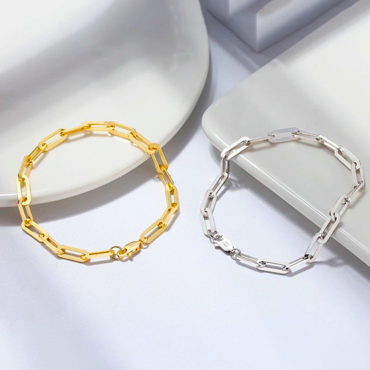 Polished gold and silver paperclip link chain bracelets side-by-side, comparing finishes for layering options